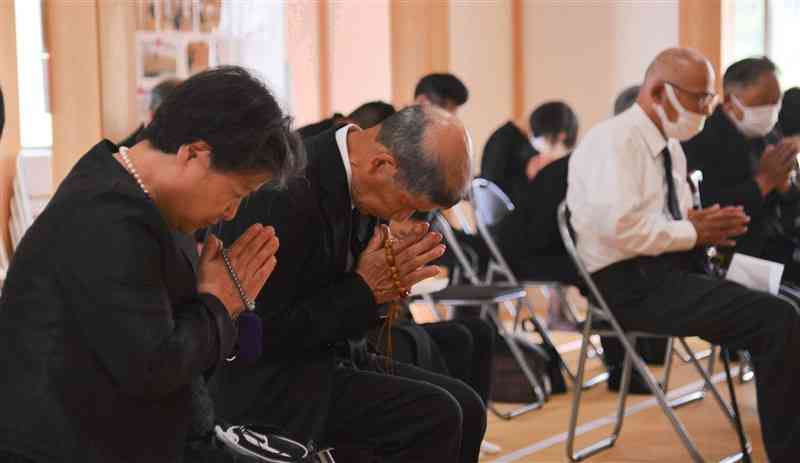熊本豪雨で行方不明となった城幸惠さんのお別れの会で、祭壇に手を合わせるおいの城文博さん（左から2人目）と裕子さん（左）夫妻＝20日、芦北町