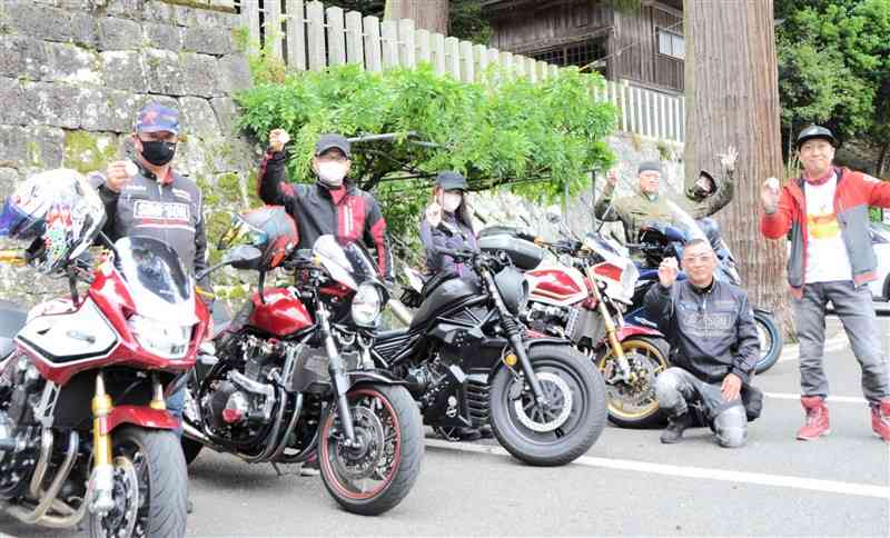 小国両神社に参拝後、安全祈願の手形を掲げるライダー＝小国町