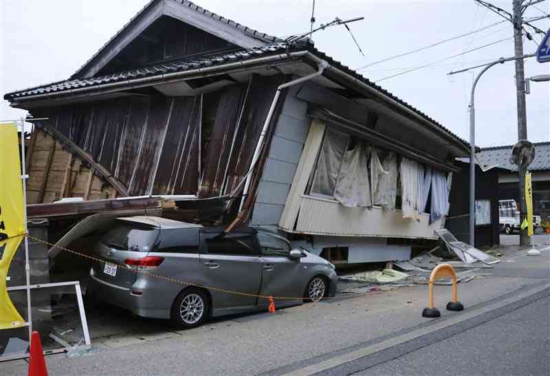 震度6強の地震でこわれ、車をおしつぶした家＝5月5日、石川県珠洲市