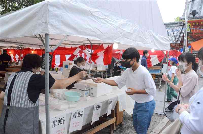 八代神社の氷室祭で蒸したての雪もちを購入する参拝者＝八代市