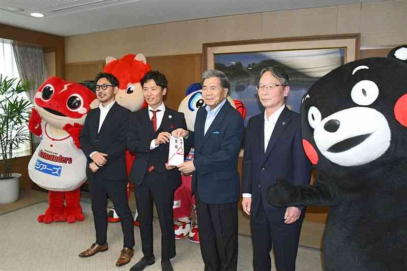 蒲島郁夫知事（右から2人目）に熊本地震の復興支援として、寄付金を贈った県内プロ球団の社長ら＝1日、県庁