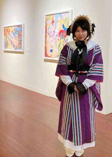 熊本市現代美術館で展示中の作品の前に立つ真珠子さん＝同市中央区