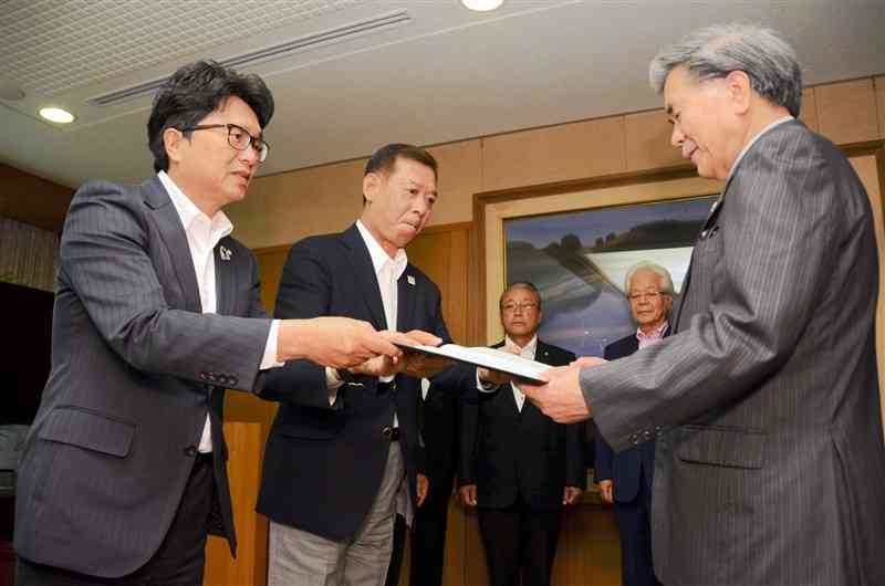 蒲島郁夫知事（右）に渋滞対策の強化を求める要望書を手渡す荒木義行合志市長（中央）と吉本孝寿菊陽町長（左）＝5日、県庁