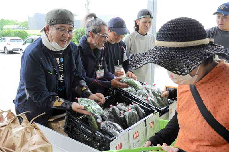 自ら栽培した野菜を販売する県立農業大学校の研修生たち＝9日、合志市