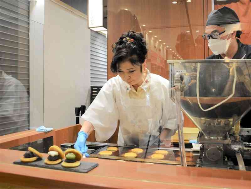 どら焼きの生地を焼く八代亜紀さん＝10日、熊本市中央区