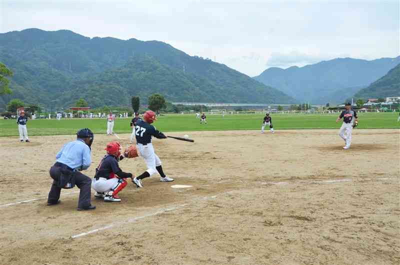 県シニアソフトボール夏季大会で熱戦を繰り広げる選手たち＝八代市