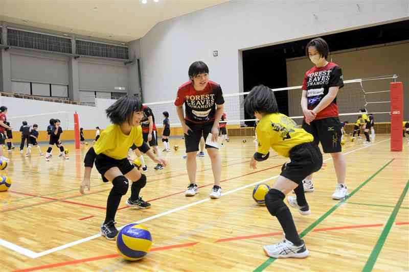 フォレストリーヴズ熊本の選手からバレーボールに必要な動きを教わる子どもたち＝芦北町