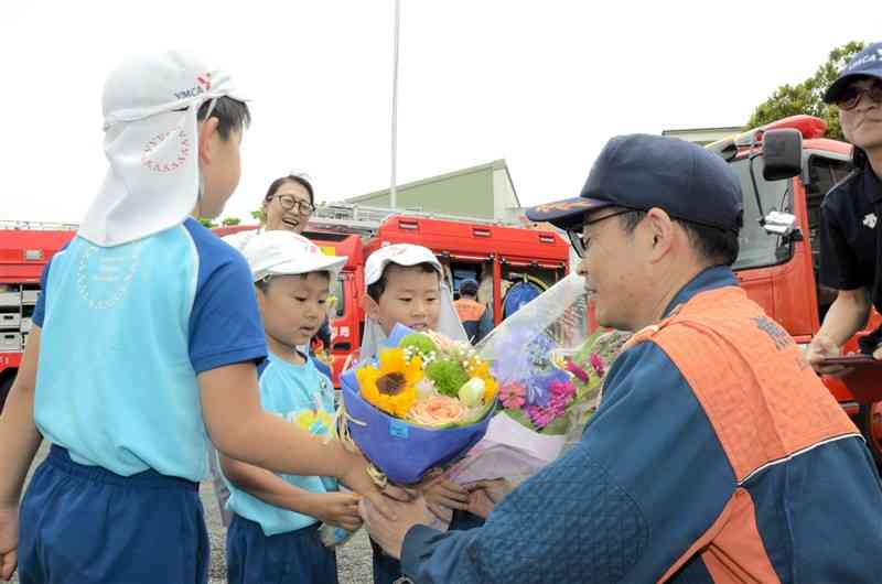 消防士に花束を手渡す園児＝熊本市南区