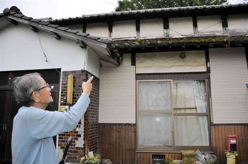 荒木大尉が少年時代、「日本一克業」と白壁に落書きした2階の部屋を指す義弟の林田忠昭さん＝14日、熊本市南区