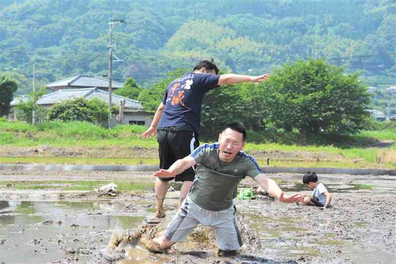 田植え前の水田を舞台に、お尻で相撲をとる参加者＝宇土市