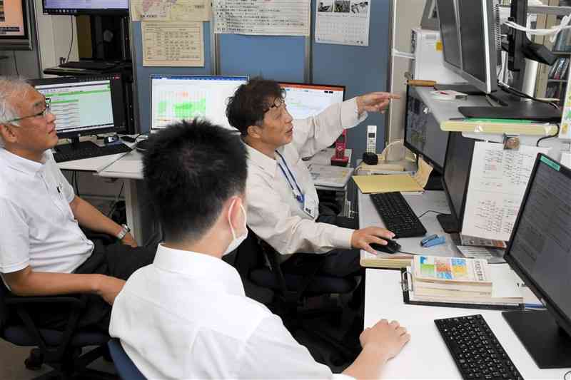 天気予報の業務にあたる熊本地方気象台の職員。気象庁は線状降水帯の予測にも力を入れている＝12日、熊本市西区