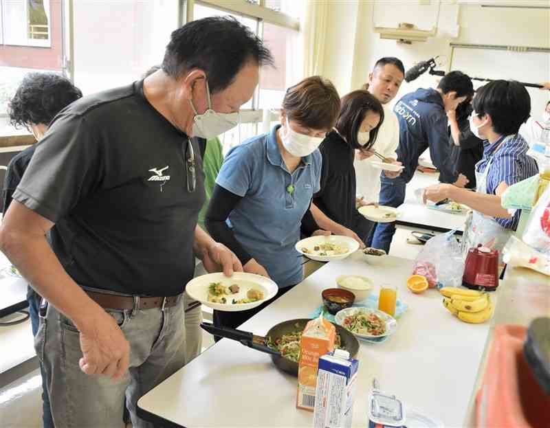 試作した1食分の食事を試食する宿泊施設の経営者ら＝水上村