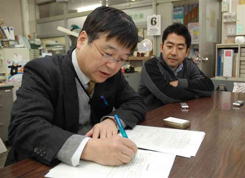水俣病を食品衛生法上の食中毒として調査するよう訴えている津田敏秀教授（左）。過去には未認定患者救済の対象外地域で確認した「メチル水銀中毒症」を保健所に届け出た＝2012年1月、天草市