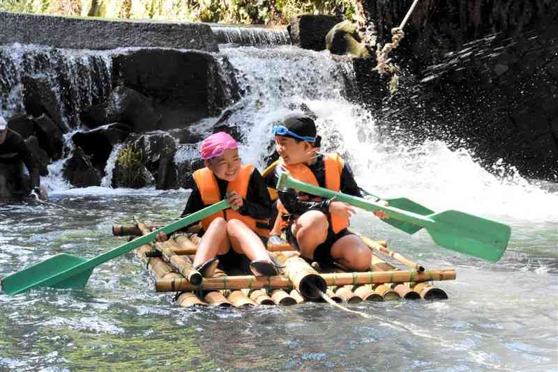 竹製のいかだに乗って川遊びを楽しむ山北小の児童＝玉東町
