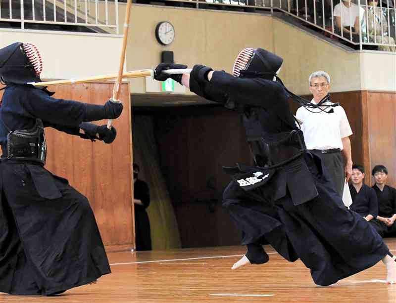 男子決勝で踏み込む槌田祐勢（県警、右）＝熊本武道館