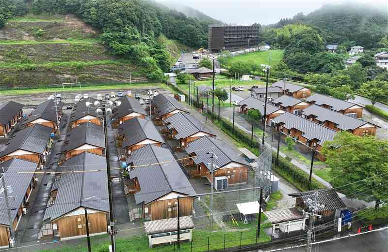 球磨村総合運動公園にある渡地区の仮設団地（手前）。奥は建設工事が進む災害公営住宅＝3日午後4時ごろ、球磨村（上杉勇太、ドローン撮影）