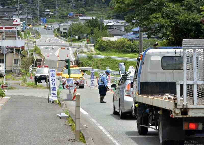 崩落した金内橋の手前から迂回する通行車両＝4日正午ごろ、山都町