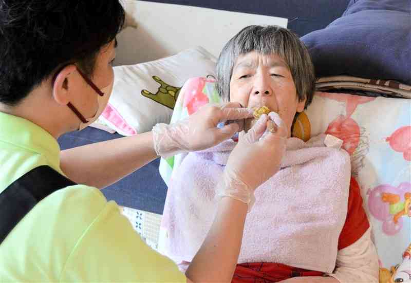 24時間体制の訪問介護を受けて生活している小児性水俣病患者の田中実子さん＝6月、水俣市