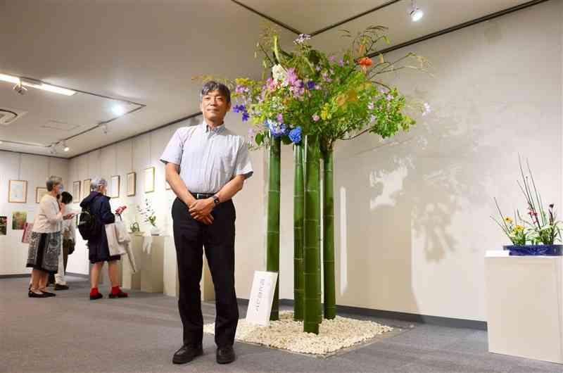 竹に花を生けた大作を手がけた草心流家元の板垣草人さん＝熊本市中央区