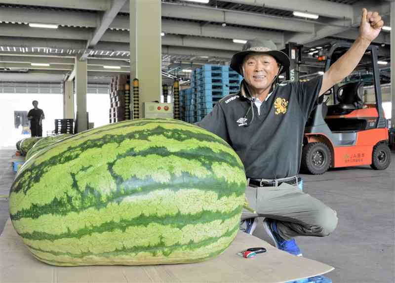過去最大132キロのジャンボスイカと栽培した菊川敏徳さん＝熊本市北区植木町