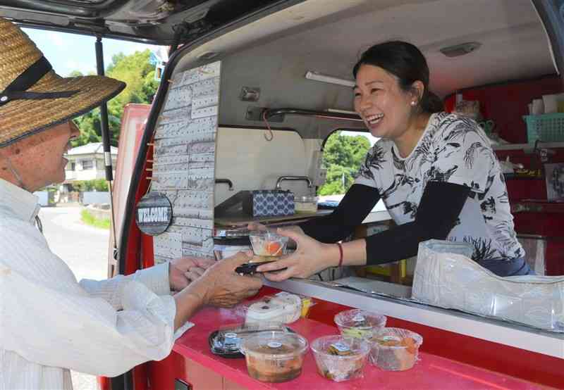 手作りの総菜を笑顔で売る神﨑芽衣さん＝上天草市