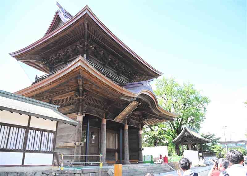 復旧工事用の素屋根が解体され、青空の下に姿を現した阿蘇神社の楼門＝阿蘇市