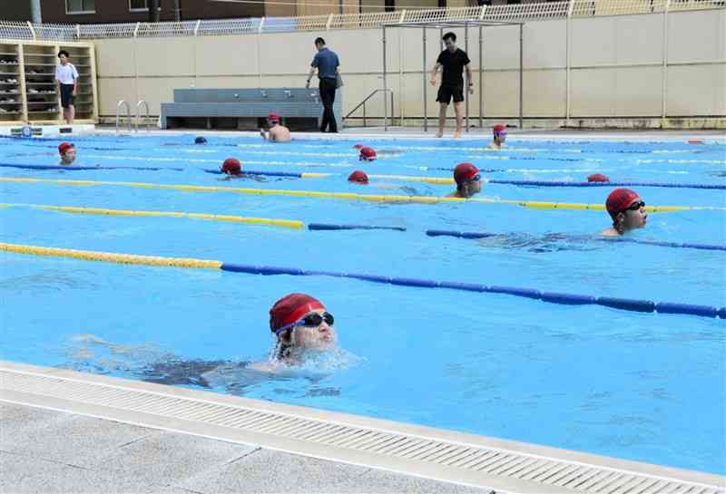 男女別に水泳の授業を実施する錦ケ丘中。男子生徒が水泳の授業を受ける間、女子生徒は運動場でソフトボールに汗を流していた＝7日、熊本市東区