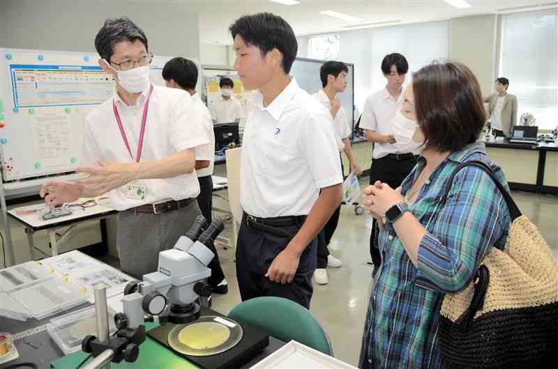 県立技術短期大学校に新設される「半導体技術科」の学習内容の説明を聞く高校生と保護者＝22日、菊陽町