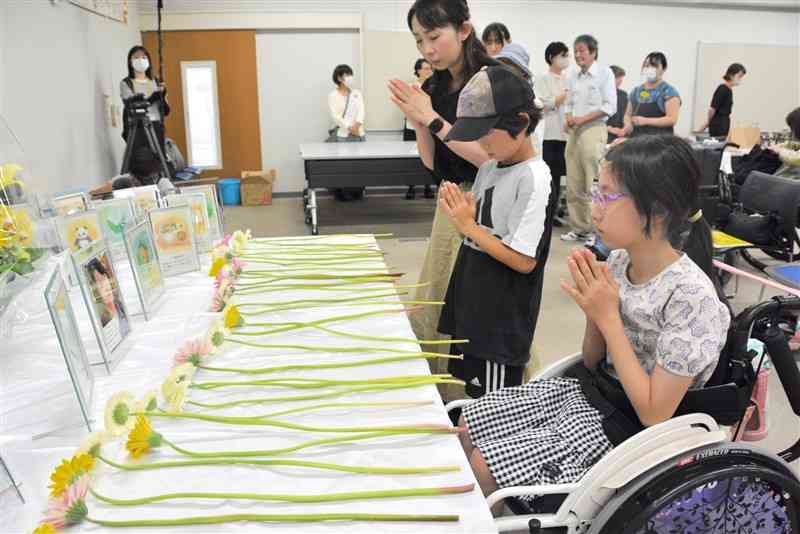やまゆり園事件の犠牲者を悼み、献花する子どもら＝23日、熊本市中央区