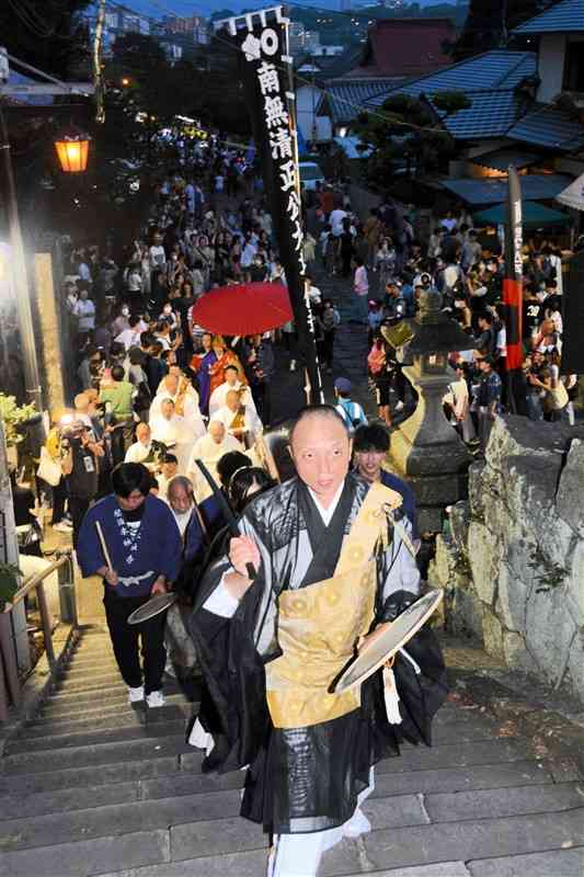 「南無妙法蓮華経」と唱えながら石段を上る「頓写会」の行列＝23日午後7時半ごろ、熊本市西区の本妙寺