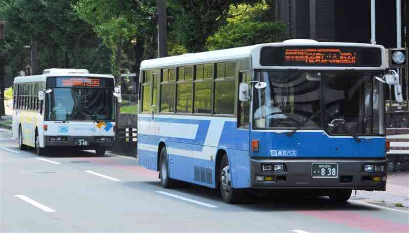熊本市役所前を走る路線バス。運行する5社は市中心部で180円の均一運賃を導入する＝24日、同市
