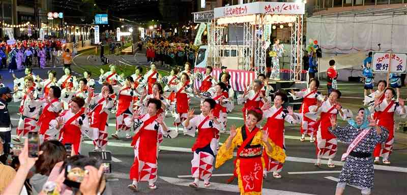音楽に合わせて楽しそうに踊り歩く参加者たち＝5日午後7時35分ごろ、熊本市中央区（鹿本成人）