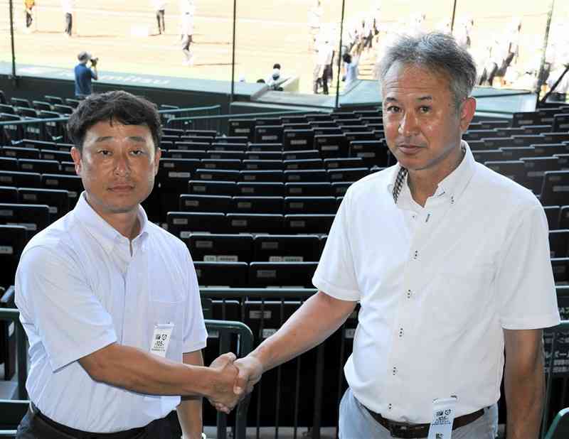 対戦を前に握手する東海大星翔の野仲義高監督（左）と浜松開誠館の佐野心監督＝5日、甲子園