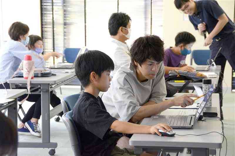 プログラミング体験でゲーム制作する児童ら＝熊本市中央区