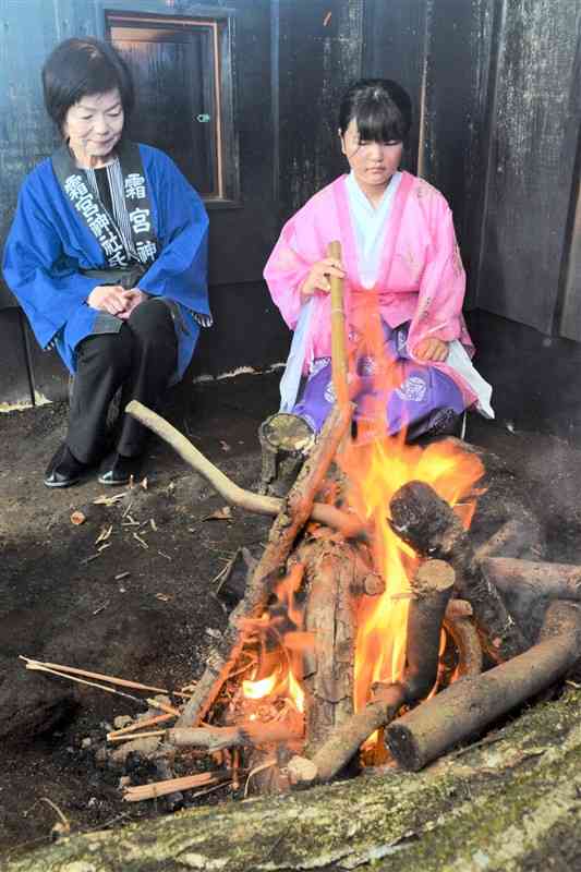火を見守る火焚き乙女の山部結愛さんと祖母の智賀子さん＝阿蘇市