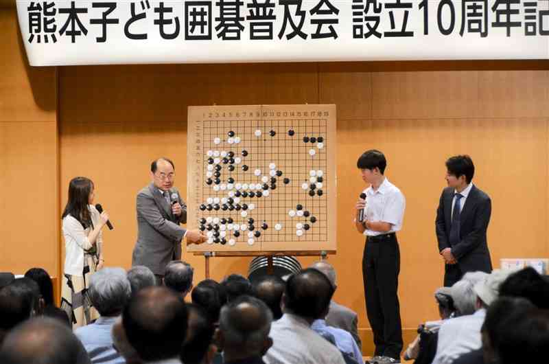 公開対局を振り返る久保秀夫七段（左から2人目）と肥後本因坊の宮本将伍さん（同3人目）＝熊本市中央区