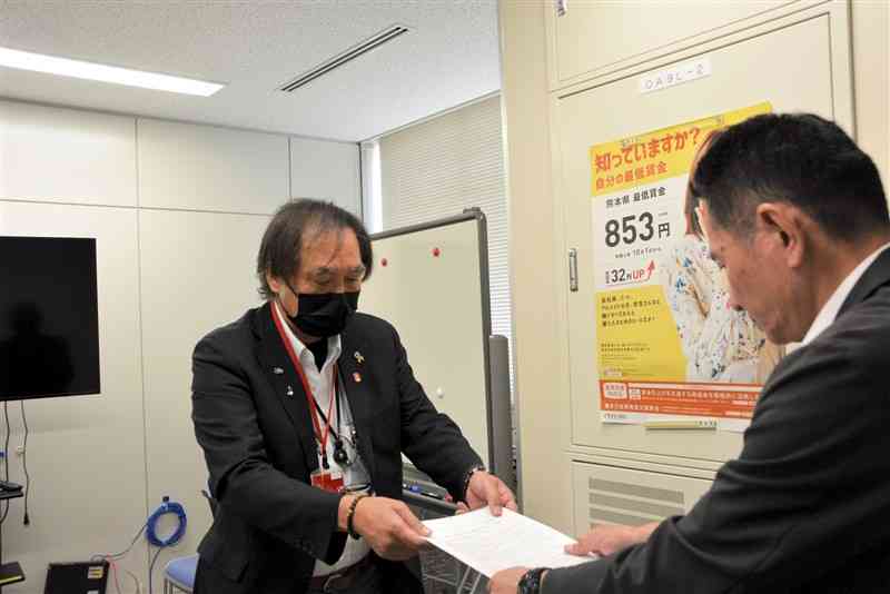 熊本労働局を訪ね、局長宛ての異議申し出書を提出する県労連の楳本光男議長（左）＝22日、熊本市西区