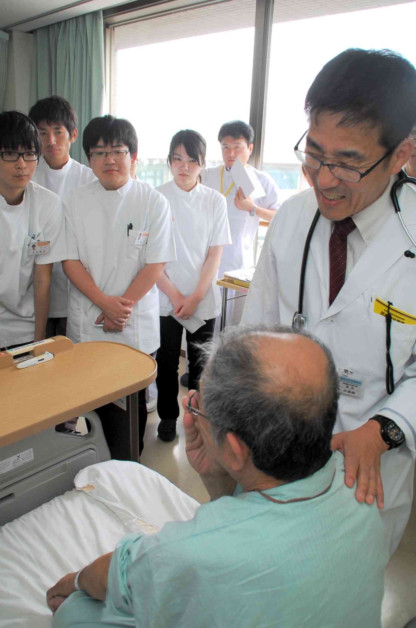 入院患者を回診する2015年当時の筆者（右）。患者に立脚した診療・研究を目指した＝熊本市の熊本大病院
