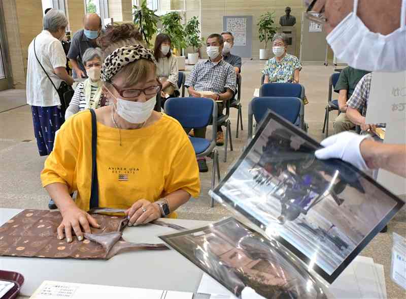 熊日写真展の応募手続きをする出品者（左）＝25日午前、熊本市中央区の熊日本社（谷川剛）