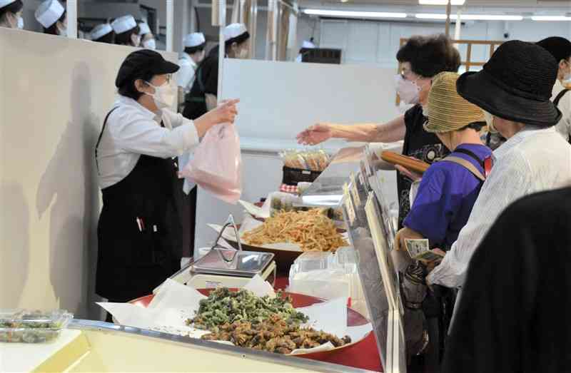 鶴屋で始まった「にっぽん味百選」で、白エビの天ぷらを購入する買い物客＝30日、熊本市中央区