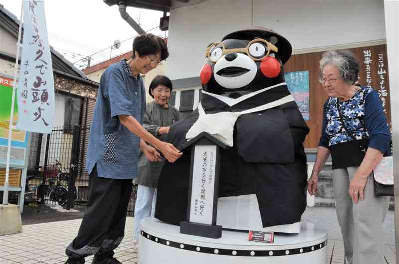 日奈久温泉観光案内所前に登場した手作りの着物を着た山頭火姿のくまモン像＝八代市