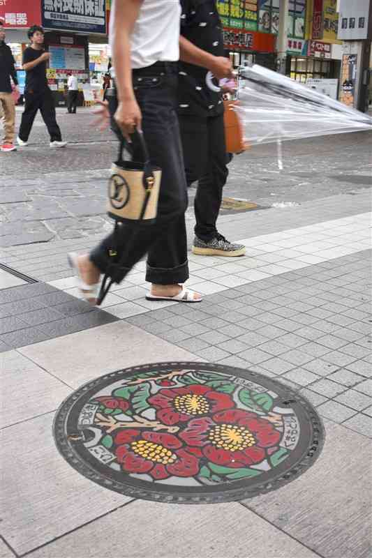肥後ツバキがデザインされたマンホールの蓋＝熊本市中央区の下通アーケード