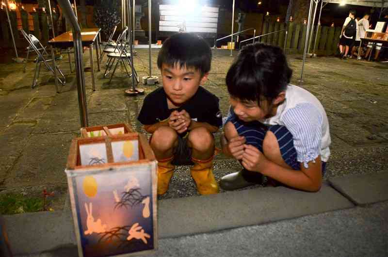 琴平神社の境内であんどんを見つめる子どもたち＝熊本市中央区