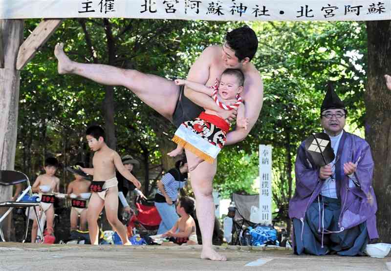 力士に抱きかかえられて土俵入りする赤ちゃん＝菊池市