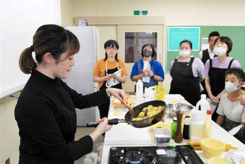 舟木慧さん（左）から「栗のキャラメリゼ」の作り方などを習う山鹿市鹿北町の飲食店主ら＝同市