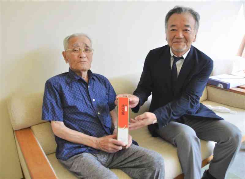 熊本善意銀行の和田浩二専務理事（右）から記念品を受け取る中川亘さん＝山都町