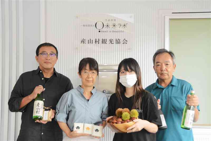 日本酒やせっけんなど、ふるさと納税の返礼品を持つ「うぶやま未来ラボ」の職員たち＝産山村