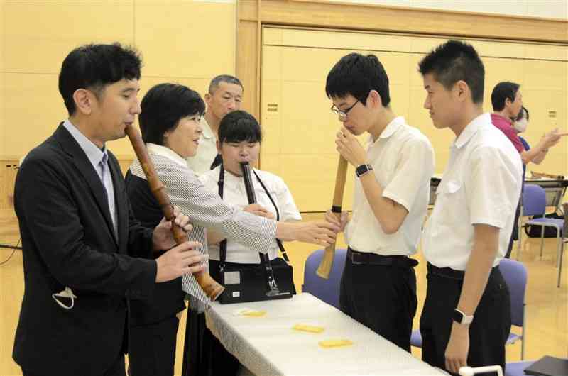 熊本盲学校の生徒たちに尺八の吹き方を教える安田知博さん（左端）＝熊本市東区