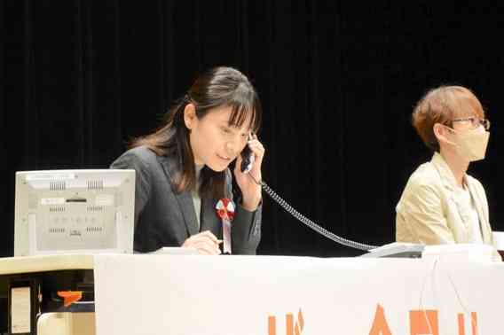 電話応対コンクール県大会で競技に臨む出場者（左）＝14日、熊本市中央区