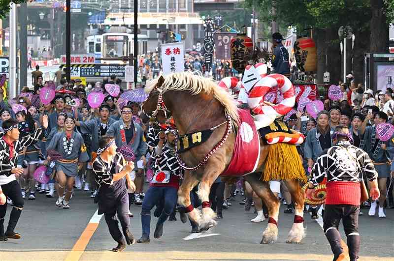 勢子の掛け声とともに、勇壮に披露された「馬追い」＝17日午前、熊本市中央区の日銀熊本支店前（鹿本成人）